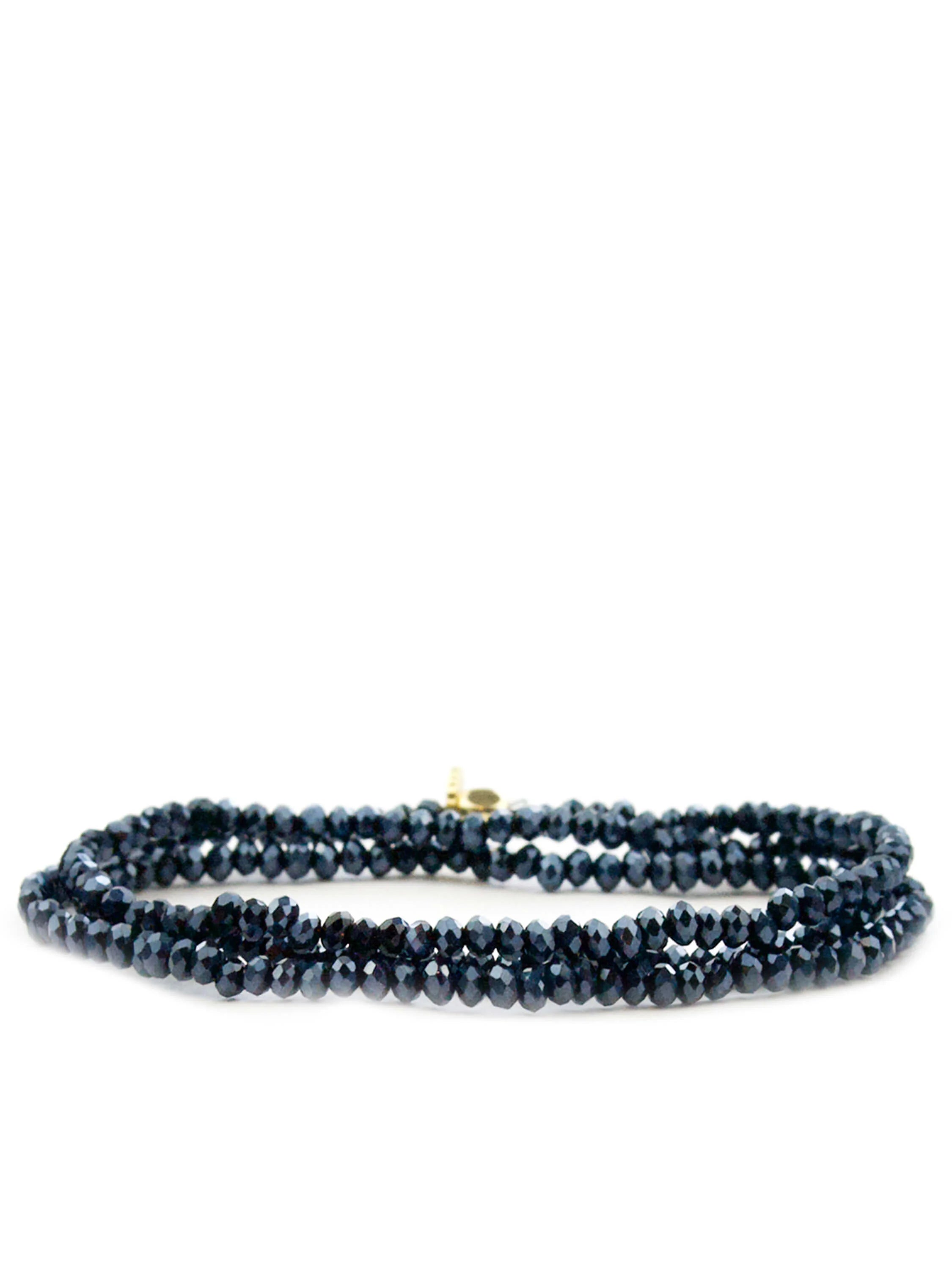 Triple-wrap bracelet with dark-blue faceted beads and small gold clasp.