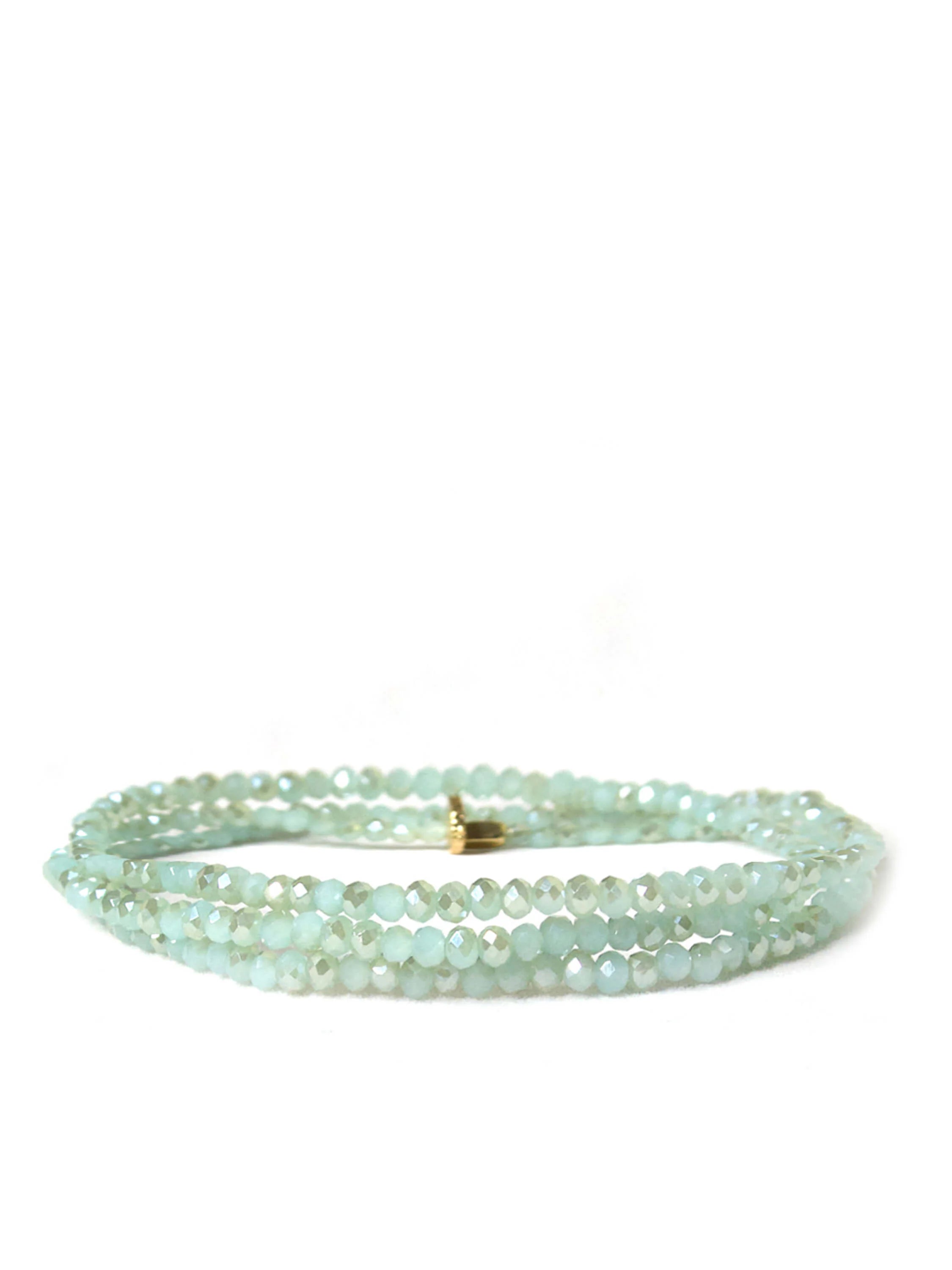 Triple-wrap bracelet with light green faceted beads and gold clasp.