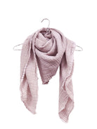Crinkled dusty pink gauze scarf with frayed edges, draped loosely over a hanger.