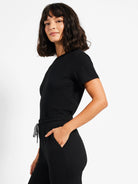 Black jogger pants with drawstring and pockets; model also wearing a black short-sleeved shirt.