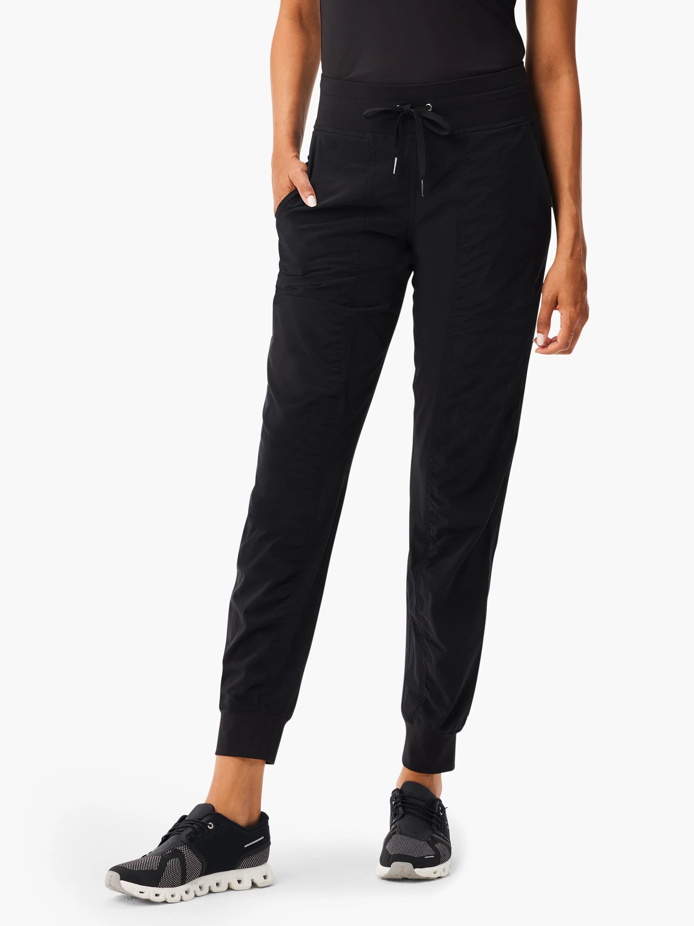 Black joggers with a drawstring waist, side pockets, and elastic cuffs. Vertical ruching visible on legs.