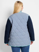 Quilted coat: light blue-grey body with dark blue sleeves and teal trim. Hexagonal pattern visible.