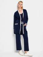 Navy blue cardigan with cream-colored trim on the collar, cuffs, and pockets.  Shown with matching ribbed pants.