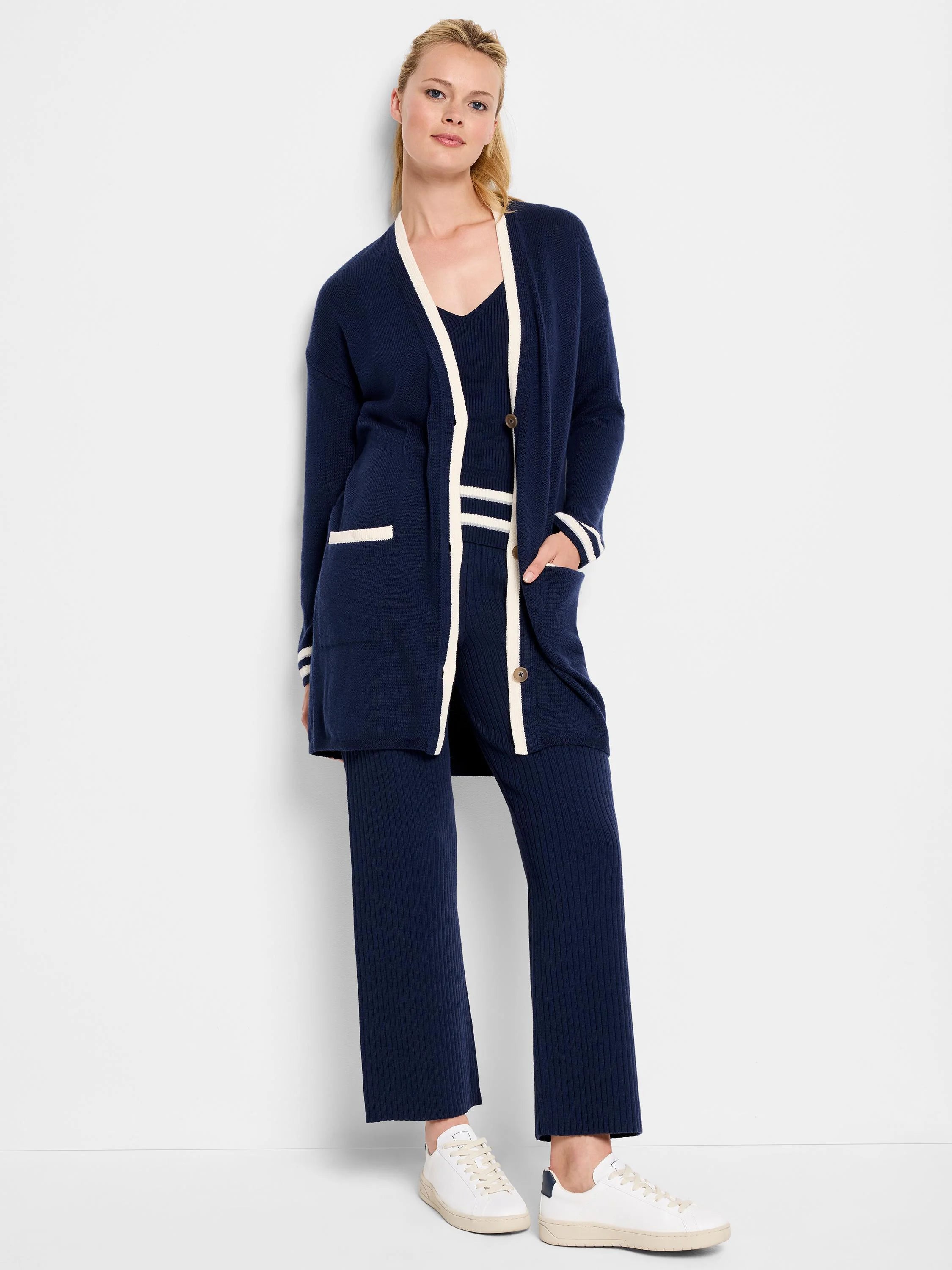 Navy blue cardigan with cream-colored trim on the collar, cuffs, and pockets.  Shown with matching ribbed pants.