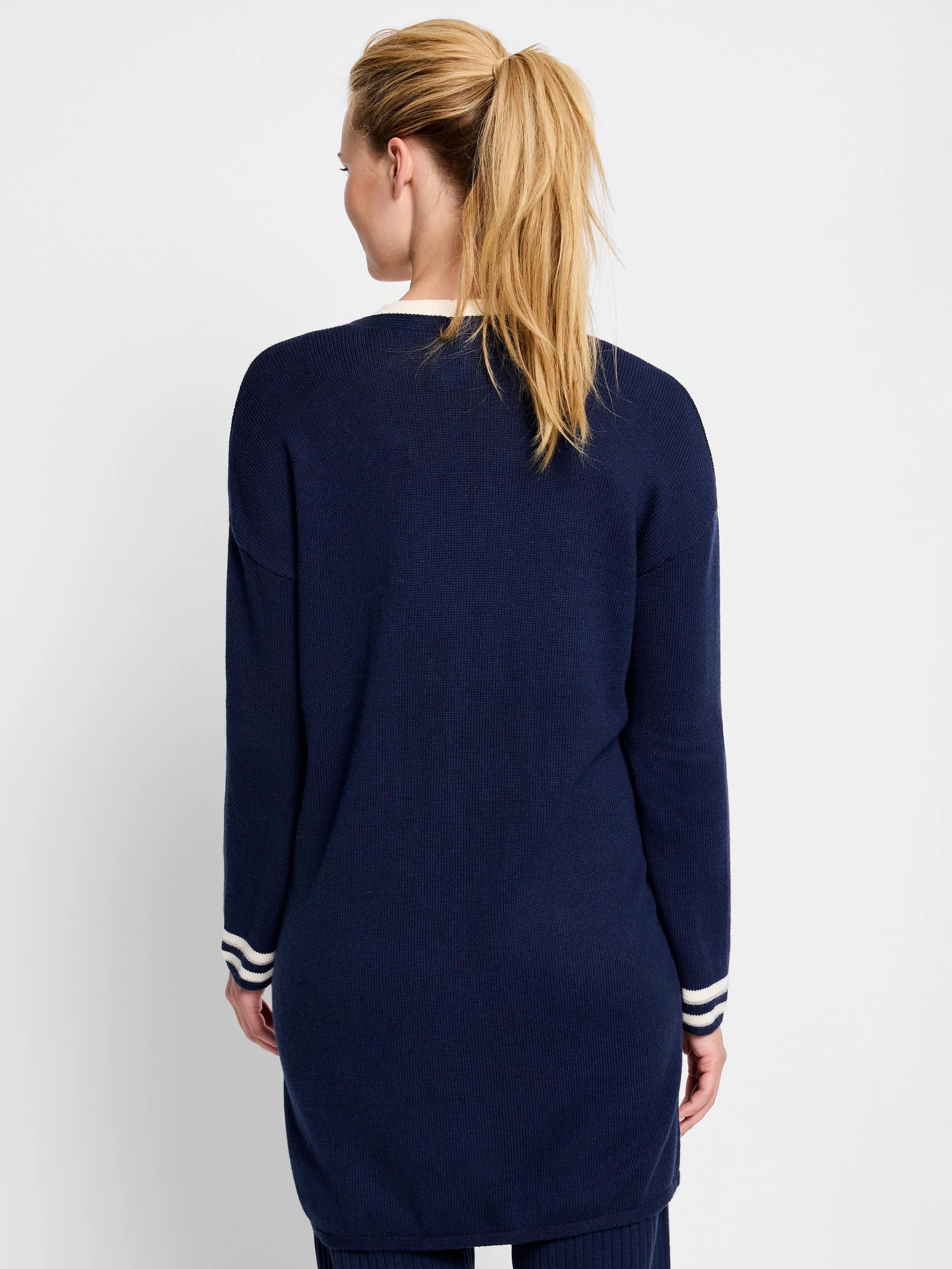Navy blue cardigan, ribbed knit, long sleeves with off-white stripes at cuffs.