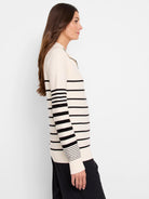 Cream-colored sweater with horizontal black stripes, half-zip closure.