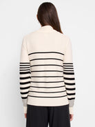 Cream-colored sweater with horizontal black stripes on body and sleeves. Half-zip neckline.