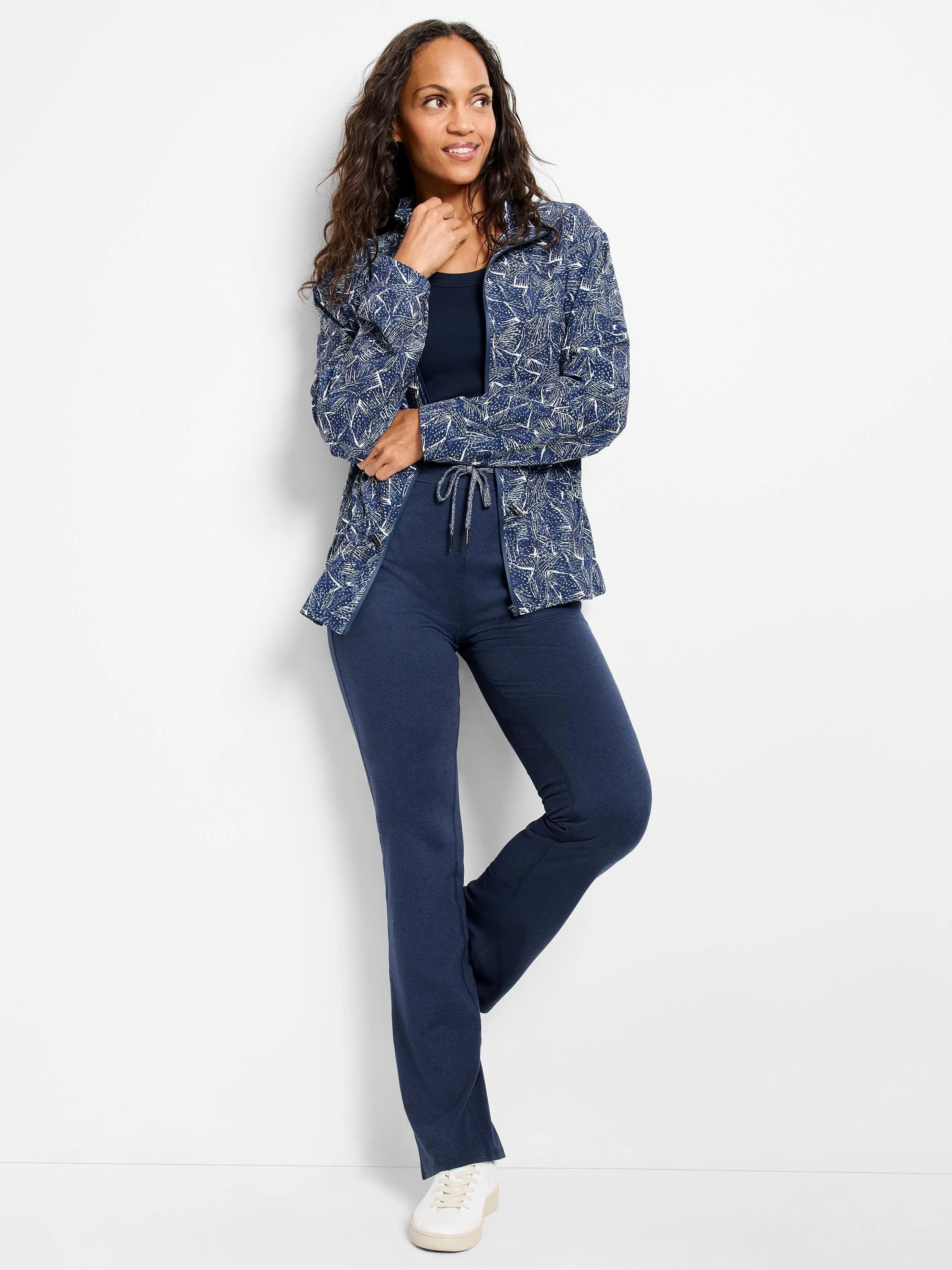 Navy blue zip-front jacket with white leaf pattern, shown with navy pants and white shoes.