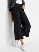 Black wide-leg cropped pants with an elastic waistband. Shown with white sneakers.