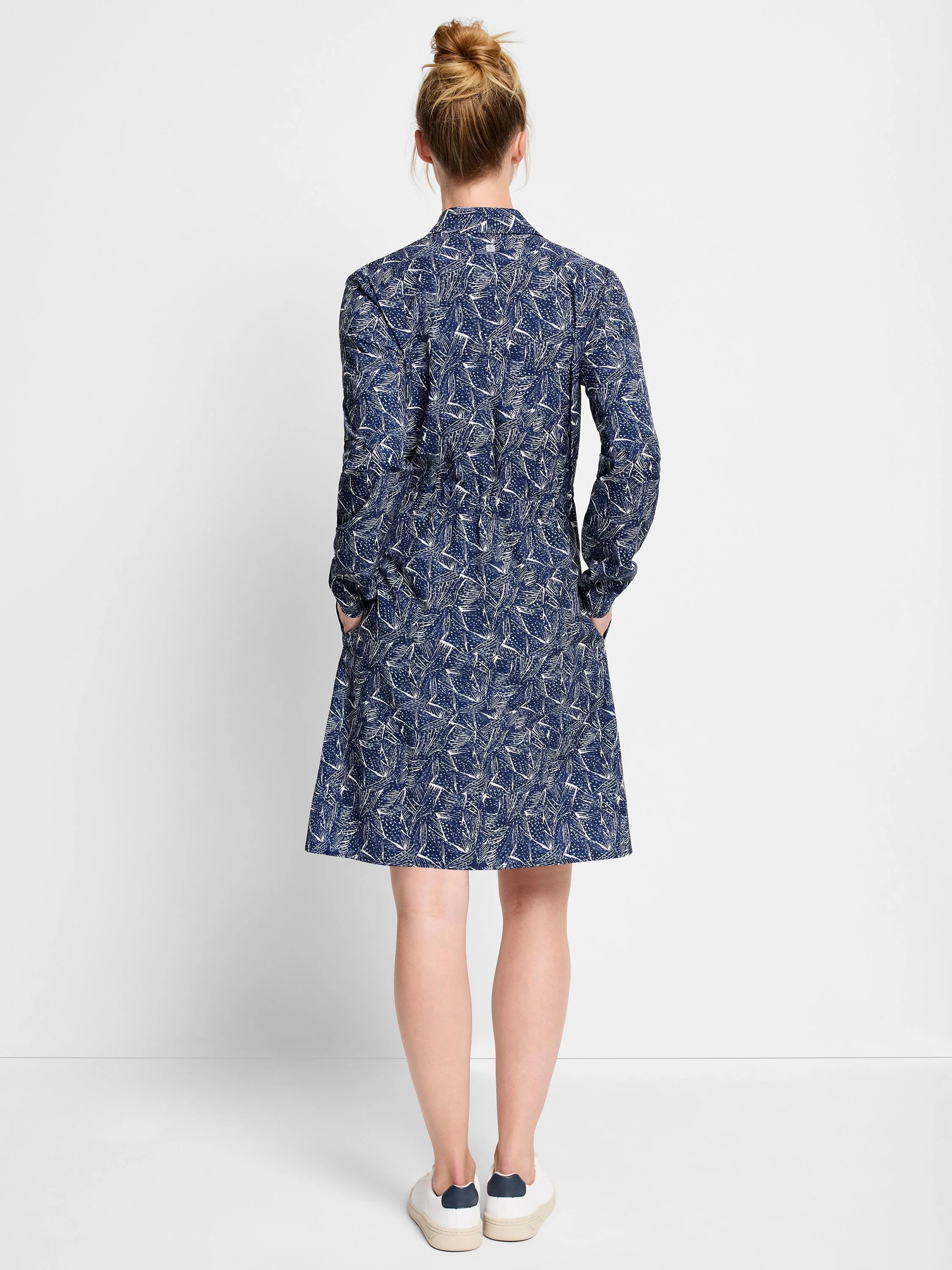 Navy blue dress with a white abstract print, long sleeves, pockets, and a knee-length A-line skirt.
