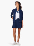 Navy blue V-neck sweater with eyelet detail at shoulders and hem.  Model also wears white sneakers and a white v-neck top...