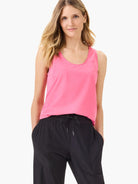 Pink sleeveless scoop-neck tank top with seaming detail.  Model also wears black pants.