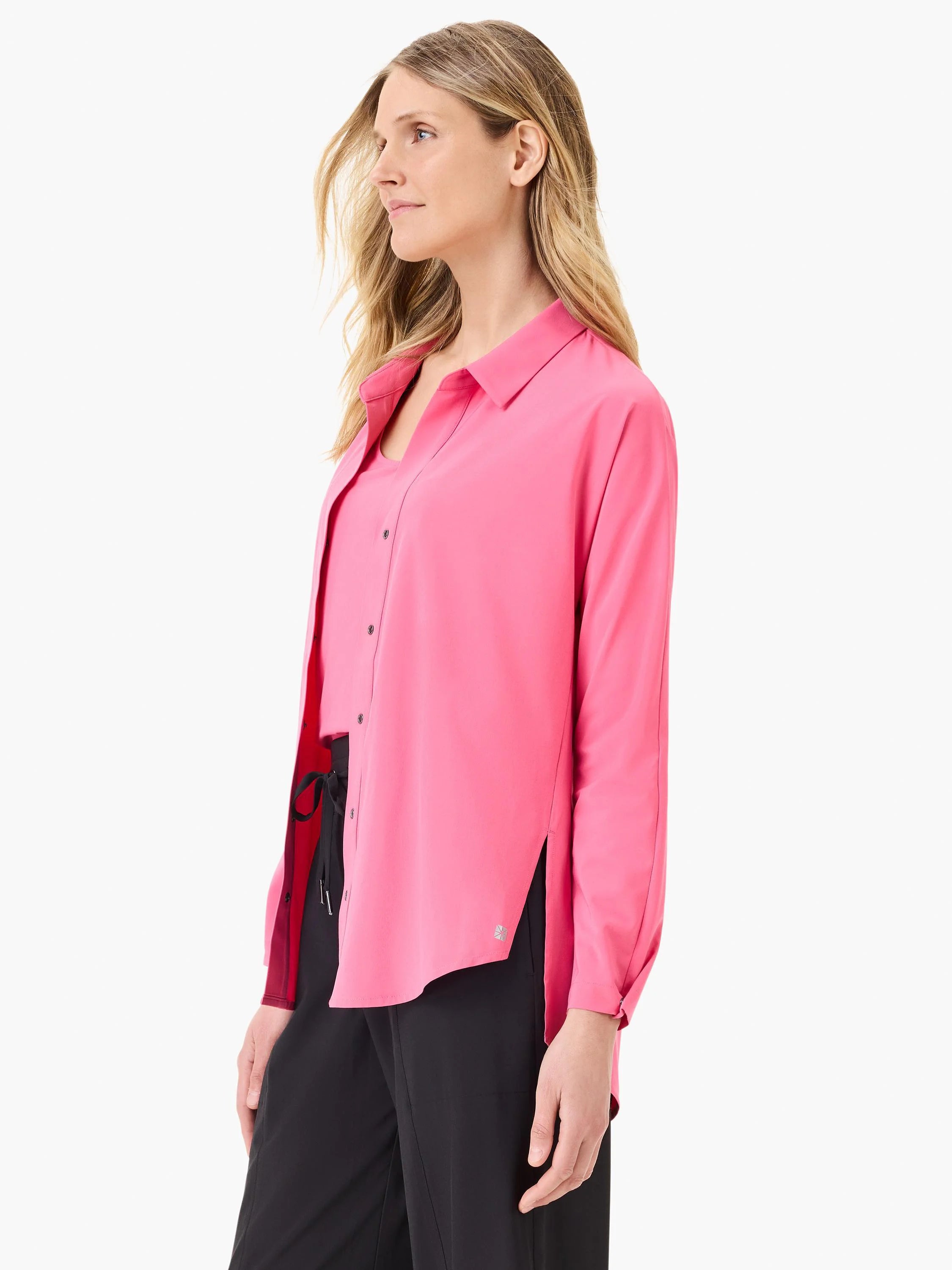 Bright pink collared button-up shirt with long sleeves and side slits, worn open over a dark top.