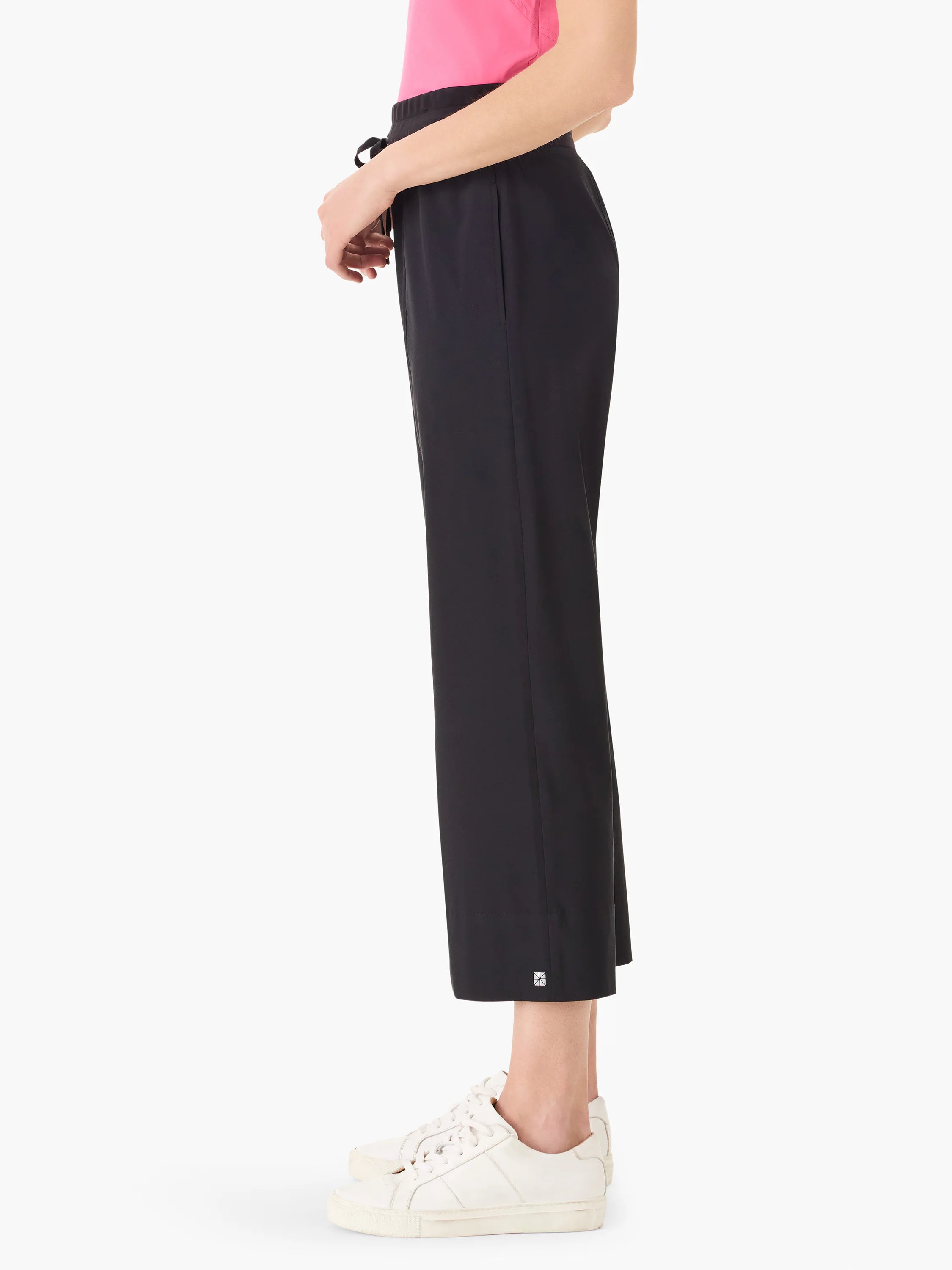 Black wide-leg cropped pants; drawstring waist.  Small logo near hem. Model wears white sneakers.