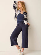 Dark navy blue wide-leg cropped pants with drawstring waist.  Model wears them with a cream and navy striped cardigan.