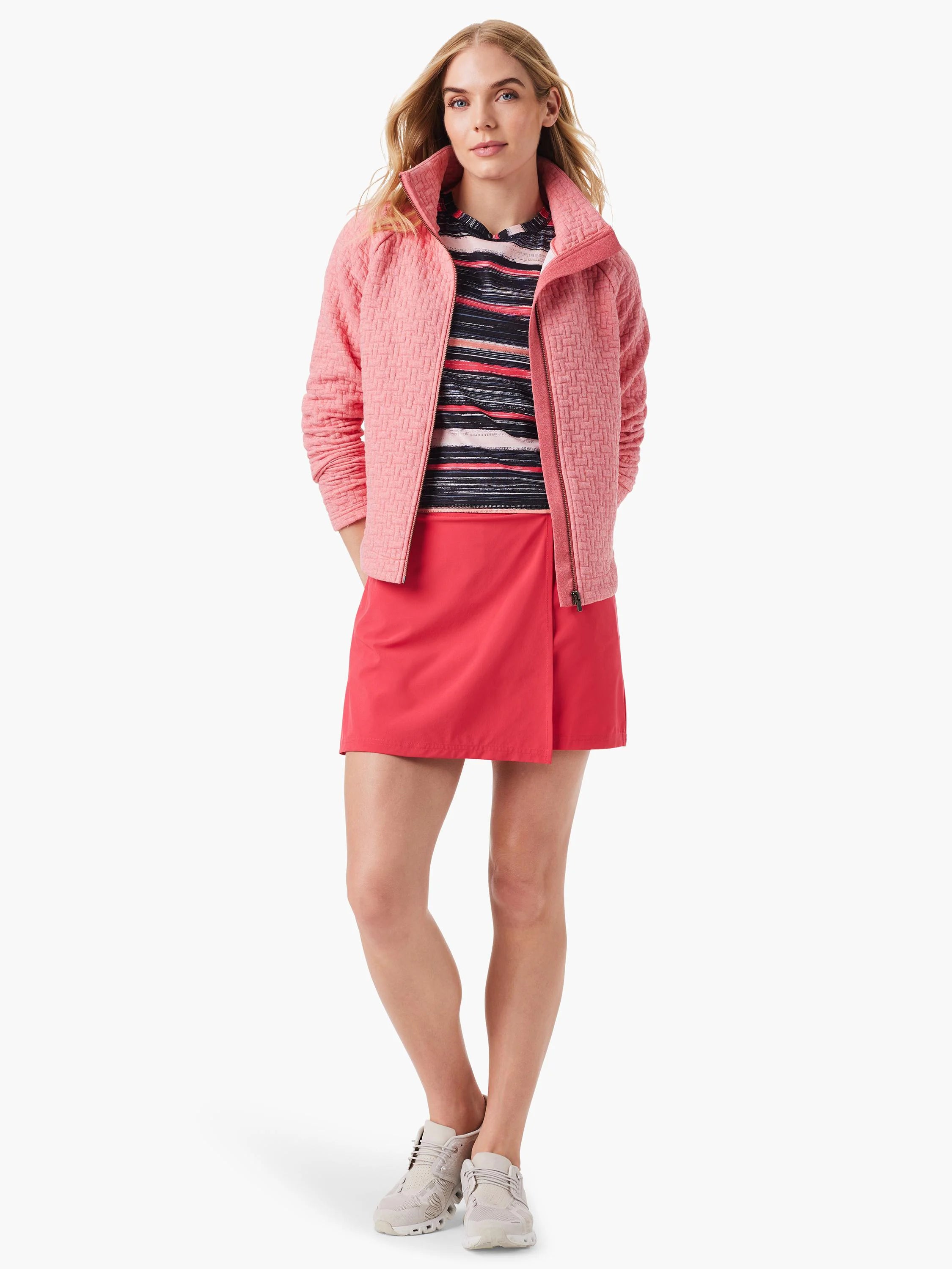 Pink textured zip-up jacket,  multicolored striped shirt, and coral skirt.  Model wears light beige shoes.