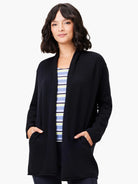 Black open-front cardigan, long sleeves, and two pockets.  A subtly striped shirt is visible underneath.
