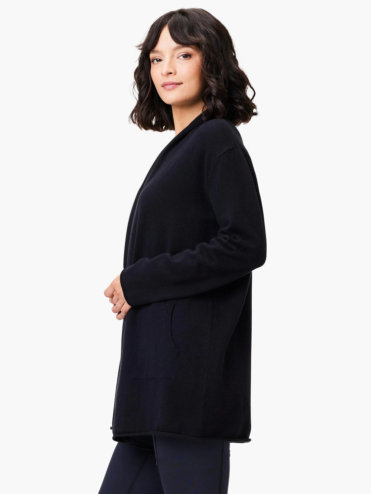 Black open-front cardigan. Long sleeves, single pocket.  Hemmed edges.