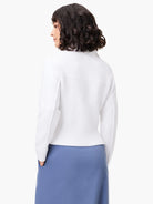 White zip-front sweater jacket, long sleeves, ribbed hem.