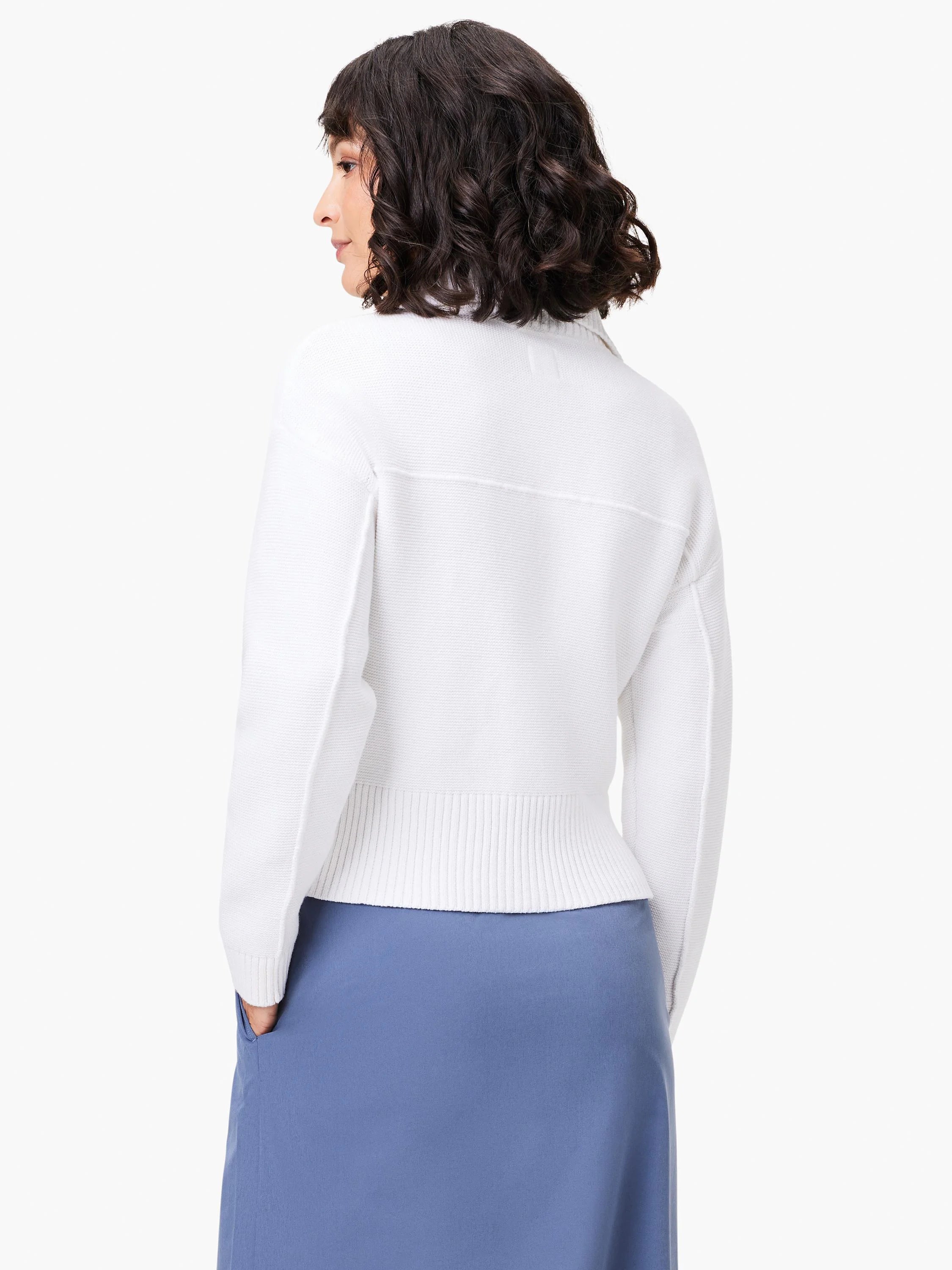 White zip-front sweater jacket, long sleeves, ribbed hem.