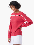 Red sweater with white, black, and small multicolored dots across shoulders and sleeves. Crew neck.