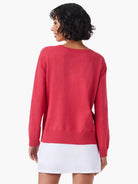 Red dotted sweater, shown from the back.  The sweater has long sleeves and a ribbed hem.