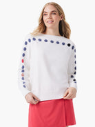 Off-white sweater with rows of small, multicolored dots (blue, pink, red) across the shoulders and down the sleeves.
