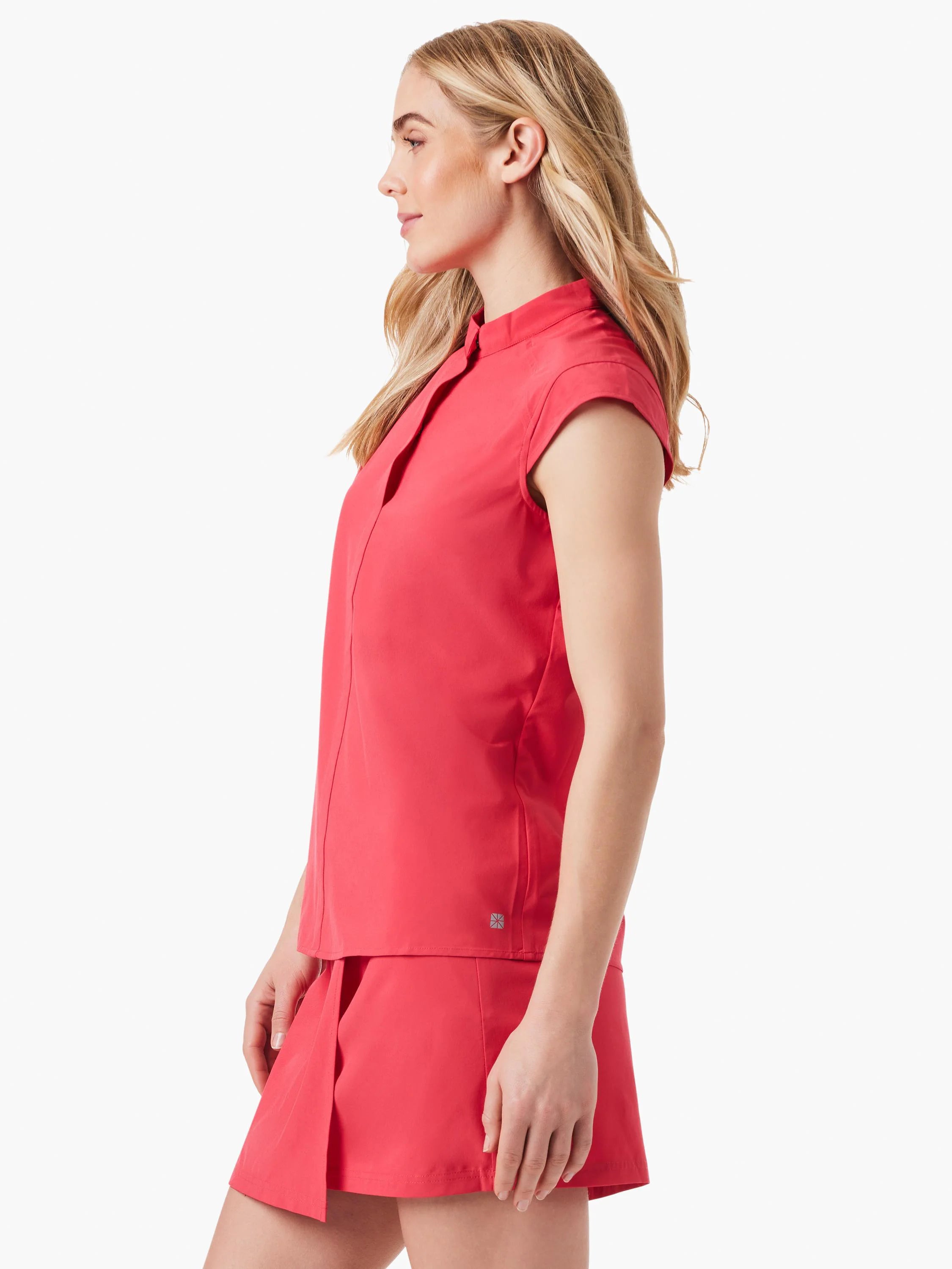 Coral pink, short-sleeved snap-neck top and matching skirt.  Side profile view.