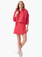 Coral zip-up jacket, matching A-line skirt.  Model wears off-white shoes.