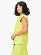 Lime green short-sleeved snap neck tank top.  Side view shows relaxed fit. Small logo near hem.