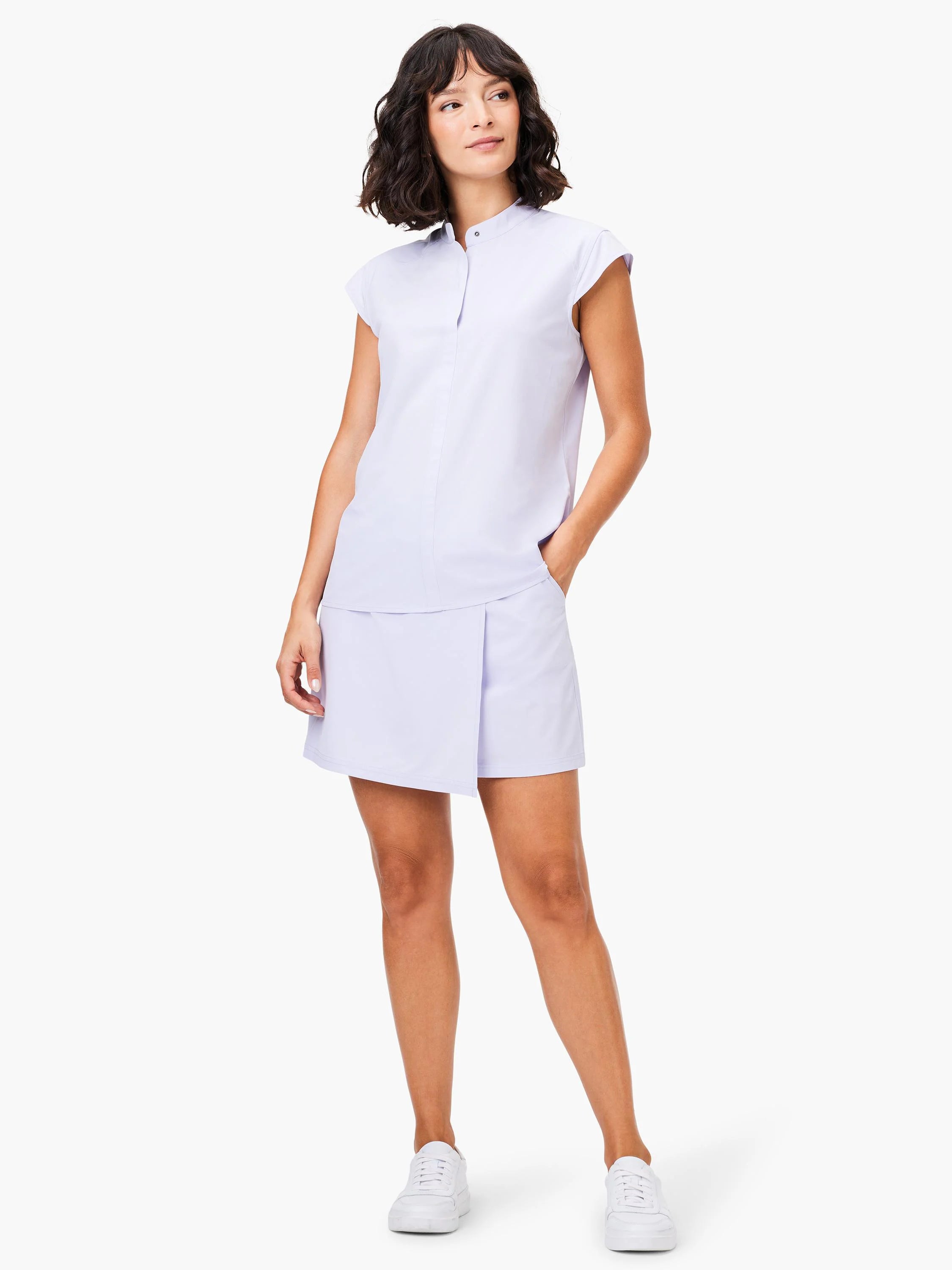 Lavender tank top with snap neck and short sleeves, paired with a matching A-line skirt.  Model wears white sneakers.