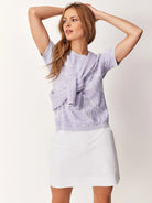White skort; lavender top with white leaf pattern; short sleeves.
