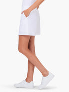 White skort; above-the-knee length, side pockets.  Model wears white sneakers.