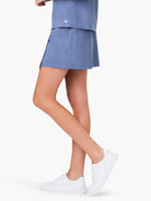 Dusty blue skort, shown on a model.  The skort is short and appears to be made of a smooth fabric.  The model also wears...