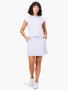 Light lavender skort and matching short-sleeved top; model wears white sneakers.