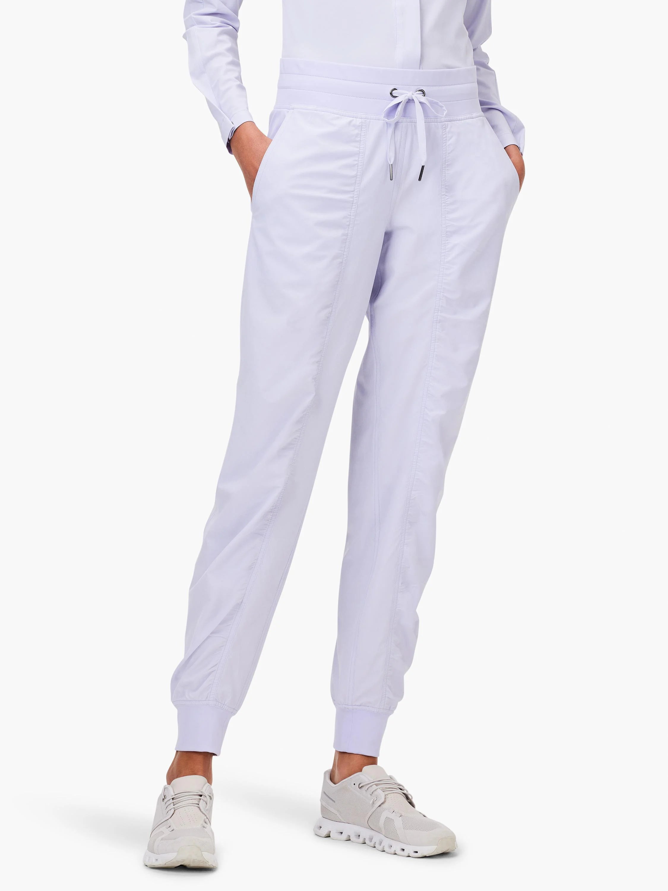 Lavender joggers with drawstring waist, side pockets, vertical front seams, and ruched ankle cuffs.