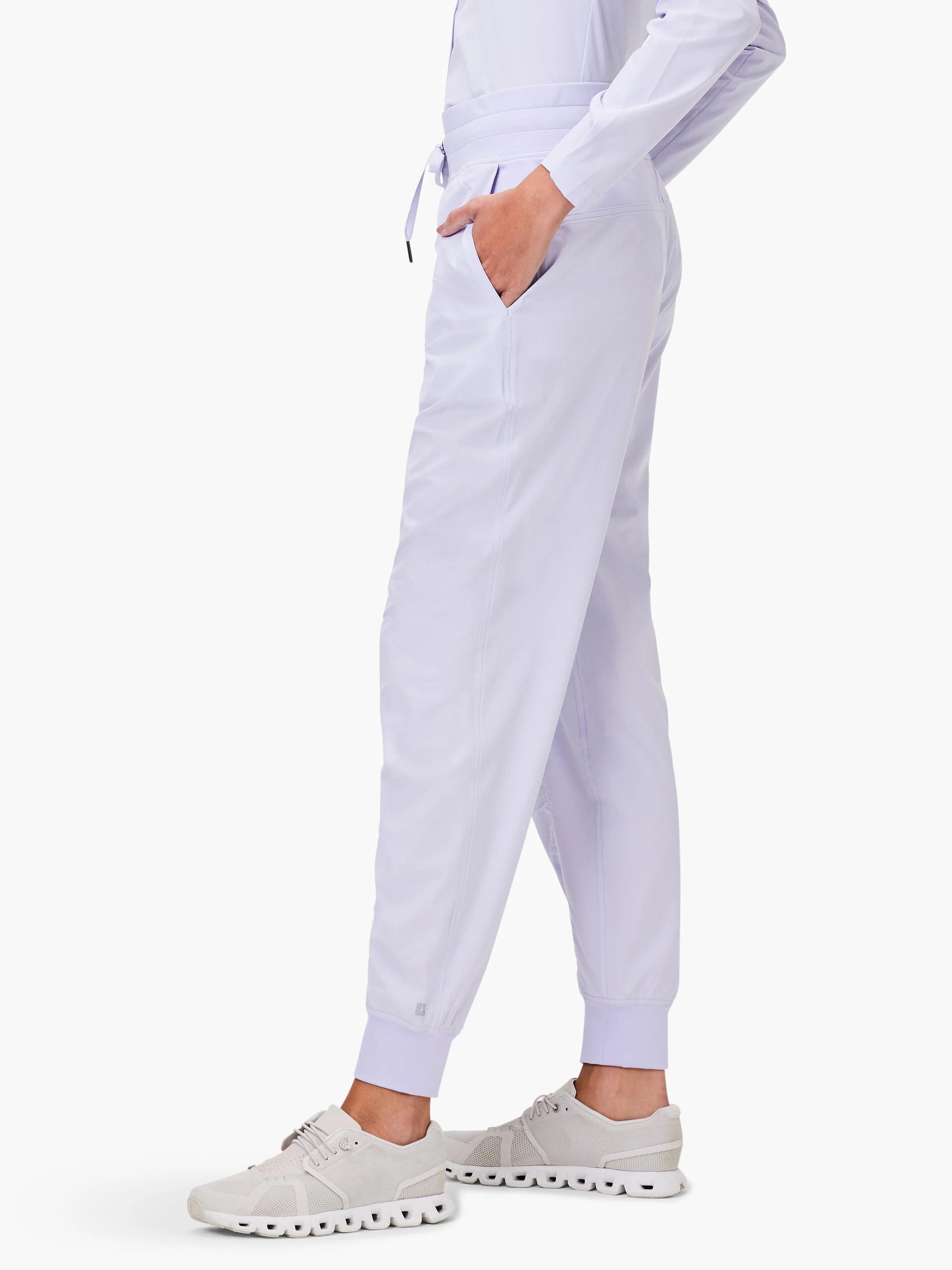 Light purple joggers with elastic waist, drawstring, side pockets, and elastic ankle cuffs.