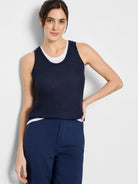 Here's alt text describing the image:

Navy blue sleeveless tank top; double layered with a white underlayer visible at...