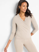 Beige, long-sleeved wrap top with V-neckline.  Three-quarter sleeves.  Matching beige pants shown.