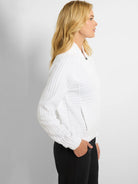 White zip-front jacket with textured, vertical stripes.  Features long sleeves and a fitted silhouette.