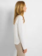 White long-sleeve polo shirt with textured vertical stripes.  Off-white background.
