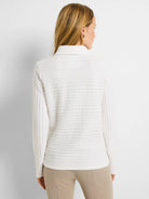 White polo shirt with textured horizontal stripes.  Long sleeves, collared.