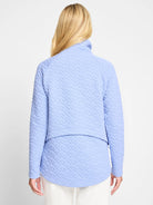 Light blue quilted jacket, long sleeves, high neck.  Diamond-shaped quilting pattern.