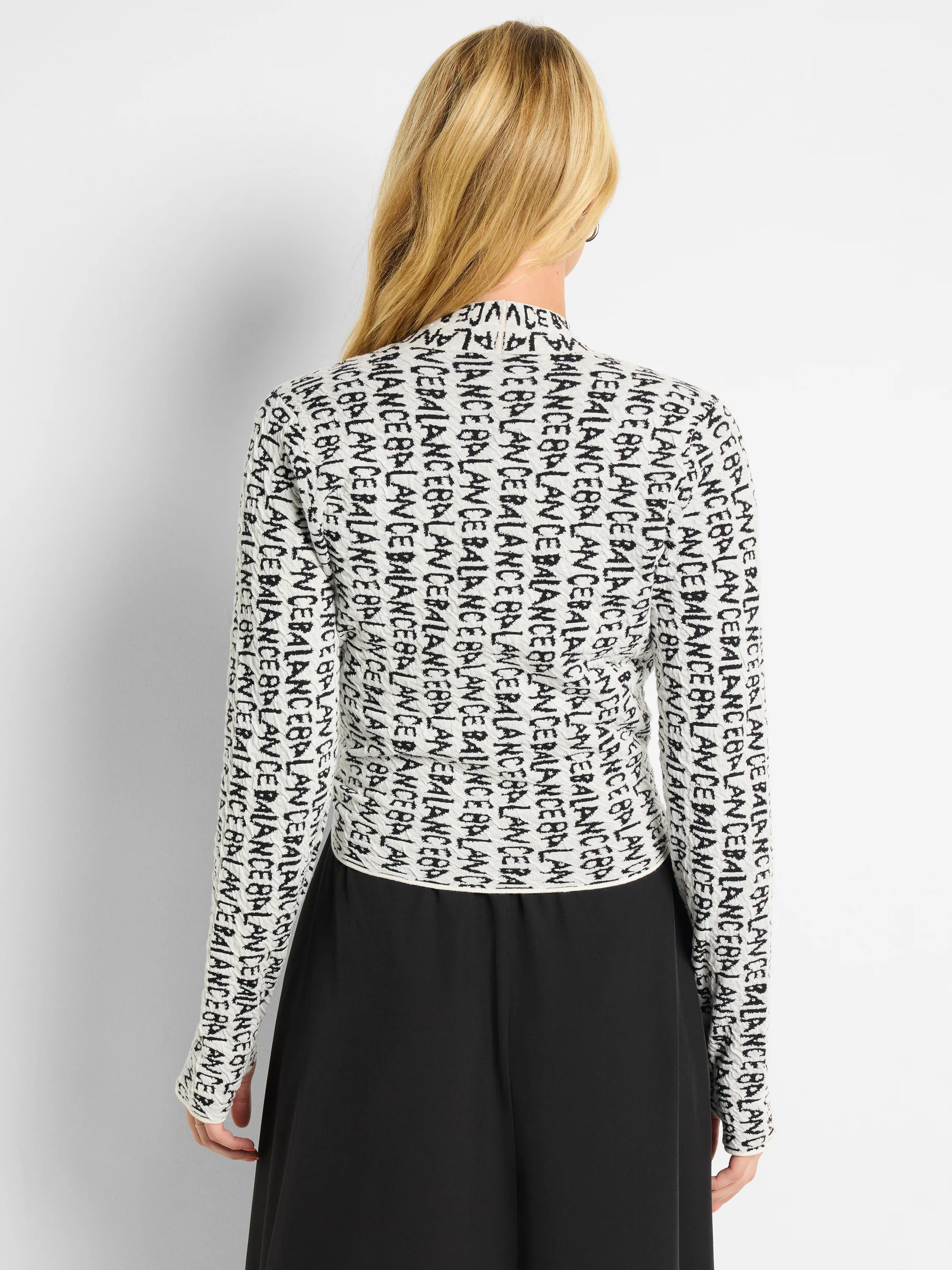 Off-white cardigan with black "BALANCE" lettering.  Long sleeves, mock neck.