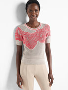 Beige mesh short-sleeve sweater with coral-pink abstract design.  Short sleeves and round neck.