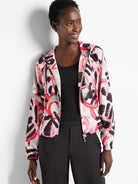 Hooded windbreaker with an abstract print in pink, black, and gray on a light background.  Zipper closure.