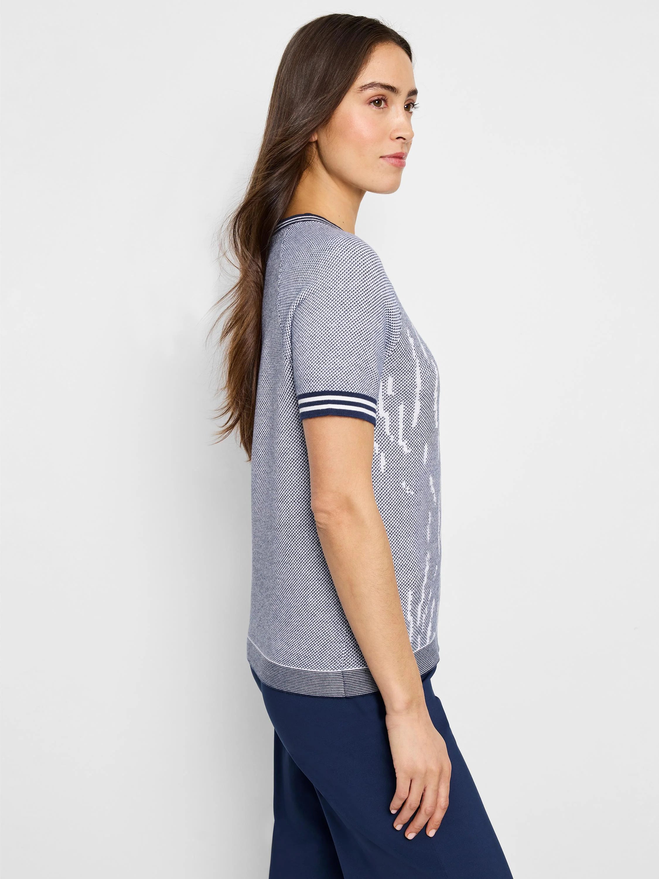 Blue short-sleeved jacquard knit sweater tee with white pattern and navy blue trim.
