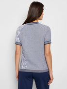 Blue and white jacquard knit short-sleeve tee.  White pattern on sleeves and hem.  Navy trim on collar and sleeves.