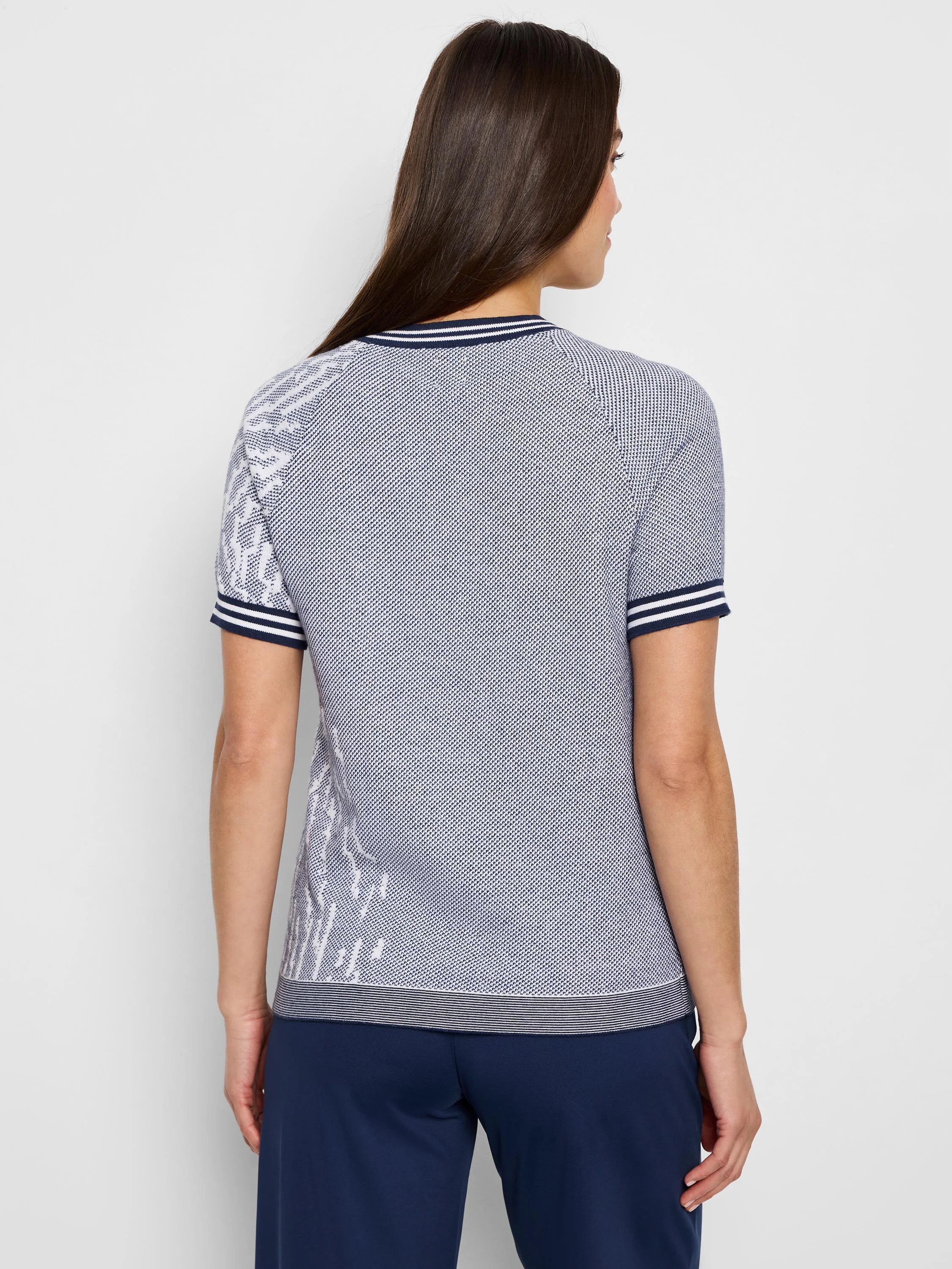 Blue and white jacquard knit short-sleeve tee.  White pattern on sleeves and hem.  Navy trim on collar and sleeves.
