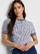 Short-sleeved navy and white sweater tee.  White abstract pattern on navy background.  Navy and white striped cuffs.